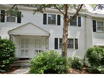 Charming townhouse with black shutters, complemented by lush landscaping, offering inviting curb appeal at 1908 Smallwood Dr, Raleigh, NC 27605