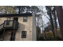Two-story condo with light beige siding, dark trim, and a balcony over the front door entrance at 311 Ashley Forest Rd # Bldg E, Chapel Hill, NC 27514
