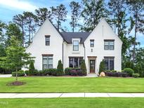 Stunning white brick home with meticulous landscaping, mature trees, and charming curb appeal at 3160 Mantle Ridge Dr, Apex, NC 27502