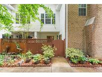 Inviting townhome entrance with a wooden gate, lush landscaping, and a charming courtyard at 320 Summerwalk Cir, Chapel Hill, NC 27517