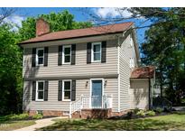 Charming two-story home with a brick foundation, fresh landscaping and a blue front door at 3317 E Jameson Rd, Raleigh, NC 27604