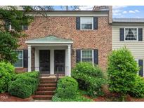 Charming two-story brick townhouse with black shutters, landscaped yard, and covered front porch at 3720 Jamestown Cir, Raleigh, NC 27609