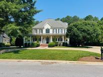 Stunning two-story traditional home with a charming front porch and meticulously landscaped front yard at 8729 Valentine Ct, Raleigh, NC 27613