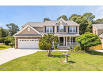 Charming two-story home featuring neutral siding, a brick-accented garage, and a well-manicured lawn at 947 Middle Ground Ave, Rolesville, NC 27571