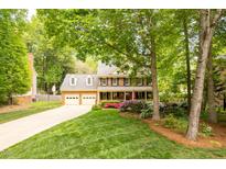 Charming two-story brick home with a manicured lawn, colorful flowerbeds and a two-car garage at 102 Pin Oak Ct, Elon, NC 27244