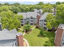Lovely aerial view of condominiums and walkways with mature trees, and lush green grass at 1061 Wirewood Dr # 303, Raleigh, NC 27605