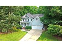Charming two-story home with a well-manicured lawn, a two-car garage, and lush, mature landscaping at 1128 Neuse Ridge Dr, Clayton, NC 27527