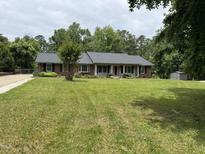 Charming single-story brick home with a well-manicured lawn and a classic red front door at 1208 Hatch Rd, Chapel Hill, NC 27516