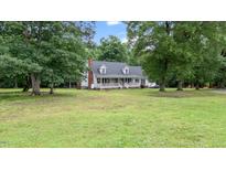 Charming home with a brick chimney and welcoming front porch surrounded by mature trees at 1401 Berea Rd, Rougemont, NC 27572