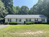 Charming single story home with a well maintained lawn, mature trees, and lovely landscaping at 145 Country Walk Ln, Sanford, NC 27332