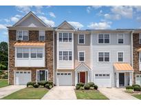 Three-story townhomes with varied facades, attached garages, and manicured front lawns create a welcoming curb appeal at 1527 Haywards Heath Ln, Apex, NC 27502