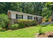 Charming single-story home with a manicured lawn, brick accents, and classic black shutters at 202 Crest Rd, Cary, NC 27513