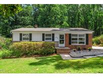Charming single-story home featuring a brick facade, well-manicured lawn, and inviting entrance, surrounded by lush greenery at 202 Crest Rd, Cary, NC 27513