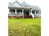 Charming home featuring a welcoming front porch with classic railings and a well-maintained lawn at 2113 Lee, Sanford, NC 27330