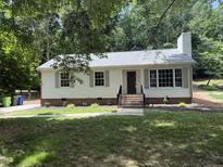 Charming single-story home with a landscaped yard and inviting brick stairs leading to the front door at 216 Burkwood Ln, Raleigh, NC 27609