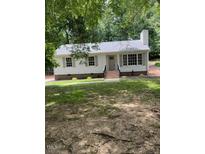 Charming single story home featuring large windows and a lush green front yard and brick chimney at 216 Burkwood Ln, Raleigh, NC 27609