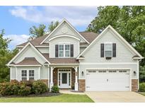 Charming two-story home featuring stone accents, a manicured lawn, and a welcoming front porch at 347 Country Mill Way, Fuquay Varina, NC 27526