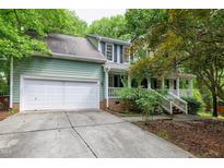 Two-story home with an attached two-car garage and a front porch, surrounded by trees at 3511 Shady Creek Dr, Durham, NC 27713