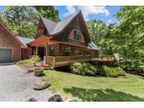 Stunning wood home with a large deck, charming design, and inviting curb appeal surrounded by lush trees at 4110 Stoneycreek Rd, Chapel Hill, NC 27514