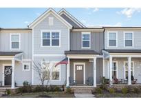 Charming townhome boasts a covered front porch, American flag, and beautiful neutral-tone exterior at 728 Silo Park Dr, Wake Forest, NC 27587