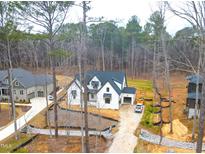 New construction home showcasing the exterior, landscaping and spacious lot in a wooded setting at 913 Harrison Ridge Rd, Wake Forest, NC 27587