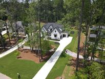 Stunning new construction, two-story home featuring a modern design and a long driveway in a lush landscape at 913 Harrison Ridge Rd, Wake Forest, NC 27587