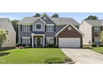 Traditional two-story home boasts manicured lawn, gray siding, and a two-car garage at 107 Trackimire Ln, Apex, NC 27539