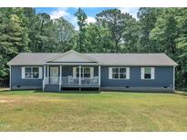 Charming single-story home with blue siding, a welcoming front porch, and a well-maintained lawn at 1118 Oakridge Duncan Rd, Fuquay Varina, NC 27526