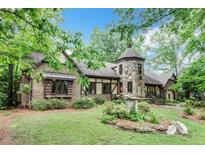 Charming Tudor-style home featuring a unique stone tower and lush landscaping at 1164 Keith Hills Rd, Lillington, NC 27546