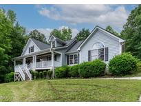 Charming two-story home with a welcoming front porch and manicured landscaping at 180 Normandy Rd, Louisburg, NC 27549