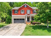 Charming two-story home with a red and beige facade, a two-car garage, and a well-manicured front yard at 1826 Fillmore Dr, Creedmoor, NC 27522