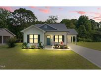 Charming home featuring a manicured lawn, cozy porch, and convenient carport at 221 Moon Cir, Dunn, NC 28334