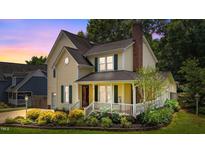 Charming two-story home featuring a brick chimney, dormer windows, and a cozy front porch with white railings at 2216 Hoskins Rd, Burlington, NC 27215