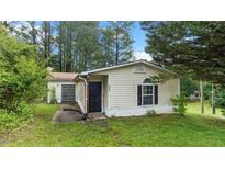 Charming single-story home with manicured lawn and mature trees at 2396 Spring Valley Rd, Henderson, NC 27537