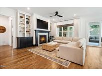 Bright living room with a fireplace, custom built-ins, and hardwood floors at 245 Tumbling River Dr, Wendell, NC 27591