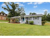 Charming one-story home with grey brick, manicured lawn, and updated landscaping at 4021 Chaucer Dr, Durham, NC 27705