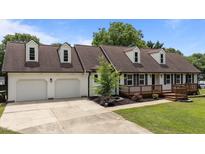 Charming two-story home featuring a two car garage, brown roof, white siding, and a covered front porch at 4259 Old Faison Rd, Knightdale, NC 27545