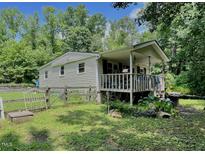 Charming single-story home featuring a covered front porch and a quaint fenced yard at 4601 Orange Grove Rd, Hillsborough, NC 27278