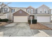 Charming townhome featuring a two-car garage, stone accents, and neutral siding at 8204 Yaxley Hall Dr, Raleigh, NC 27616