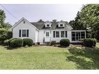 Charming two-story home with green lawn, bushes, and white picket fence at 931 Eastern Ave, Nashville, NC 27856