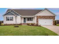 Charming single-story home featuring stone accents, manicured lawn, and a welcoming front porch at 10725 Farmall Dr, Middlesex, NC 27557