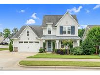 Charming two-story home with a well-manicured lawn, lush landscaping, and a welcoming entrance at 1124 Cedar Farm Trl, Fuquay Varina, NC 27526