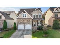 Charming two-story home featuring a stone facade, attached two-car garage and beautifully landscaped front yard at 130 Virginia Water Dr, Rolesville, NC 27571