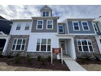 New construction townhome with stone accents, gray and white siding, and available lots sign at 1945 Plott Balsam Dr, Wendell, NC 27591