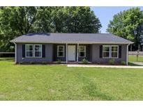 Charming single-story home featuring a well-manicured lawn and gray siding at 420 E Grandview Ave, Liberty, NC 27298