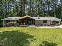 Charming brick home with a well-manicured lawn and a welcoming teal front door at 5809 Kimbal St, Raleigh, NC 27606