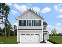 Charming two-story home featuring a two-car garage, with blue shutters, green lawn and professional landscaping at 616 Impala, Wendell, NC 27591