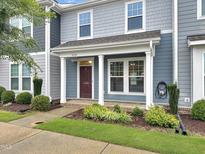 Charming townhome featuring a welcoming front porch, well-manicured landscaping, and a blue exterior at 6536 Perry Creek Rd, Raleigh, NC 27616