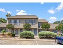 Inviting two-story townhome with neutral siding and charming blue shutters and well maintained landscaping at 72 Justin Ct, Durham, NC 27705