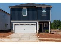 New two-story home with a white garage door and dark blue siding under a clear, bright sky at 800 Ottawa Dr, Garner, NC 27529